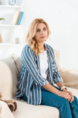 evde yumuşak oyuncak yakın kanepede oturan sinirli kadın 