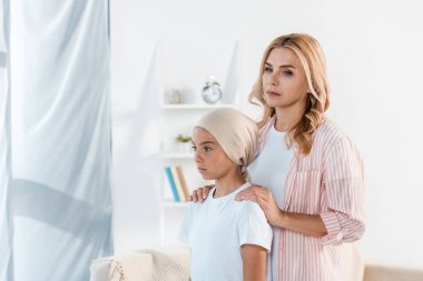üzgün anne evde hasta kızı yanında duran 