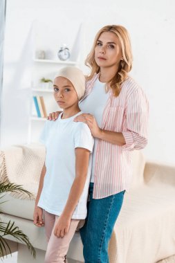 upset mother standing near sick daughter at home  clipart
