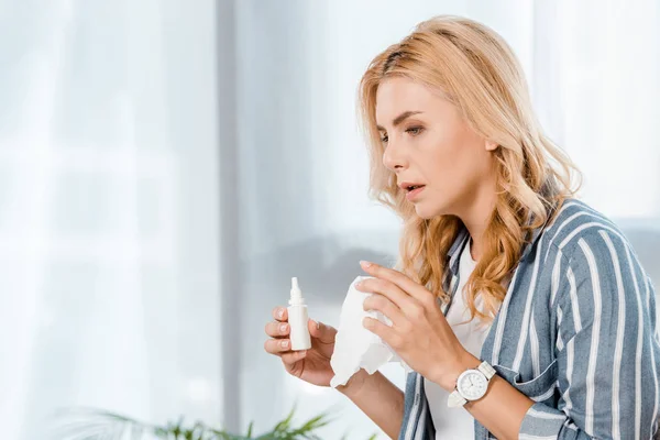 自宅で鼻スプレーとナプキンを持つ病気の女性 — ストック写真