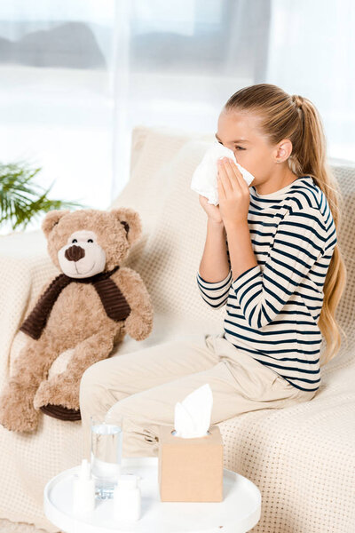 sick kid sneezing in tissue neat teddy bear 