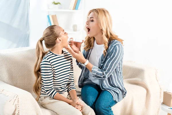 Madre Sosteniendo Spray Para Dolor Garganta Cerca Hija Con Boca — Foto de Stock