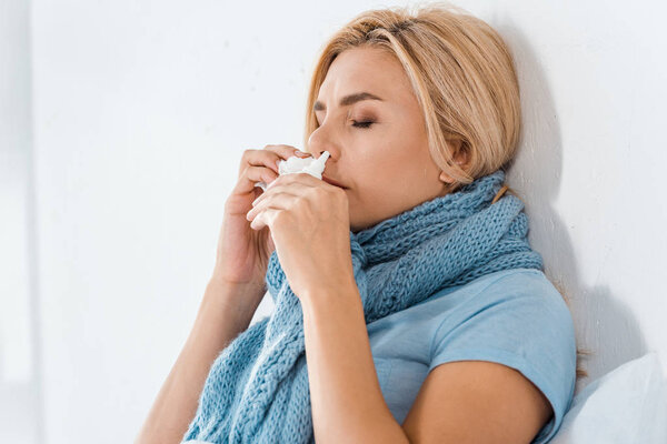 больная женщина с закрытыми глазами с помощью носового спрея в спальне
 