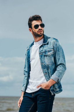 denim ceket ve güneş gözlüğü yakışıklı adam uzağa bakıyor