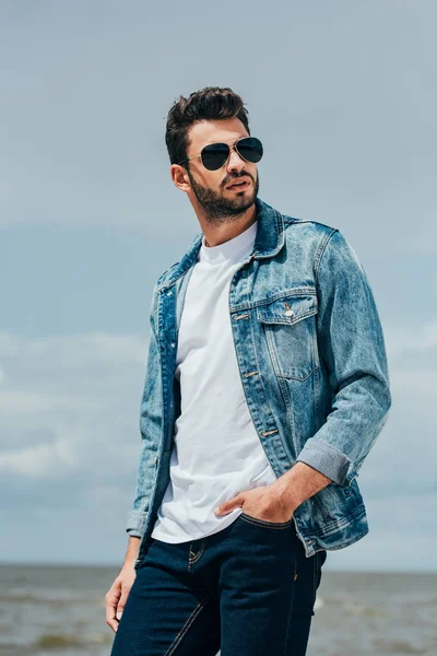 denim ceket ve güneş gözlüğü yakışıklı adam uzağa bakıyor