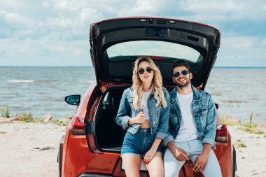 kot ceketler dışında gülümseyen çekici kadın ve yakışıklı adam 