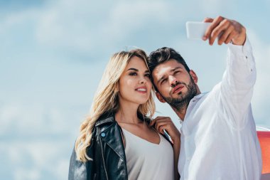 çekici kadın ve yakışıklı adam gülümseyerek ve selfie alarak 