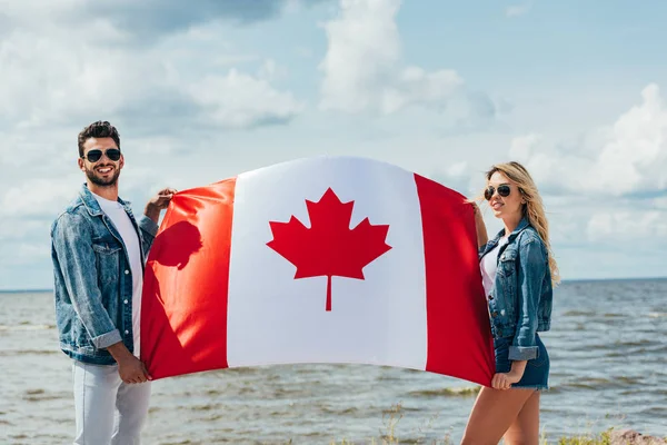 Atractiva Mujer Hombre Guapo Sonriendo Sosteniendo Bandera Canadiense — Foto de Stock