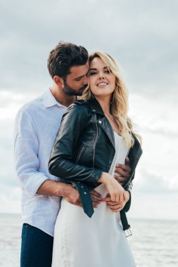 çekici kadın ve yakışıklı adam gülümseyerek ve dışarıda sarılma 