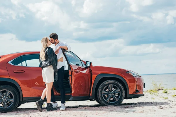 有吸引力的女人和英俊的男人亲吻和拥抱附近的汽车 — 图库照片