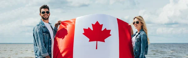 Tiro Panorâmico Mulher Atraente Homem Bonito Sorrindo Segurando Bandeira Canadense — Fotografia de Stock