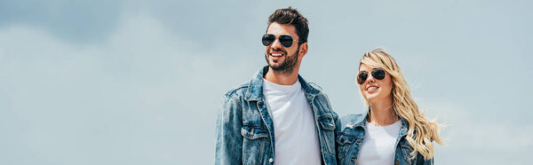 panoramic shot of attractive woman and handsome man in denim jackets smiling outside 