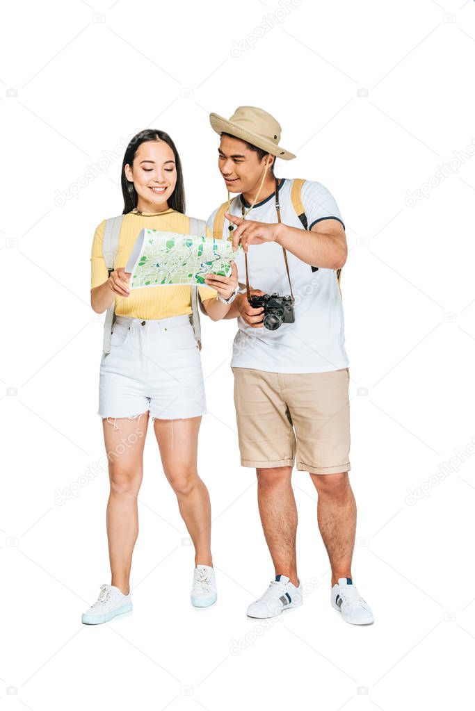 handsome asian man pointing with finger while looking at map with girlfriend on white background