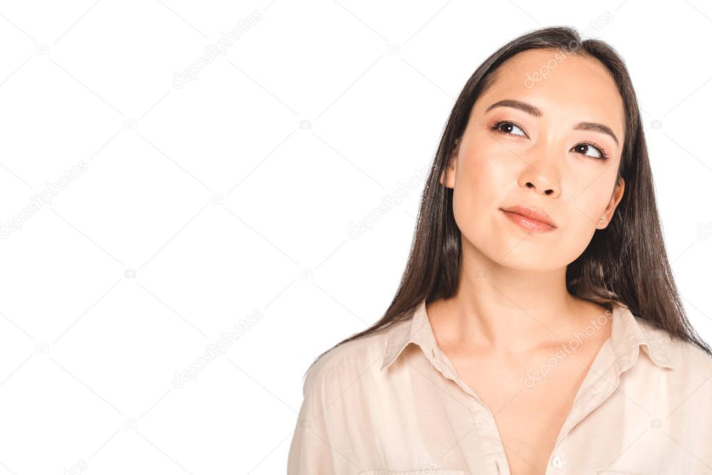 young, pensive asian woman looking away isolated on white