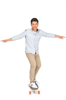 beyaz arka plan üzerinde kamera bakarken genç yakışıklı asyalı adam sürme longboard