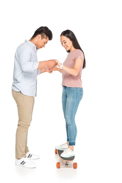 Handsome Asian Man Helping Girlfriend Riding Longboard White Background — Stock Photo, Image