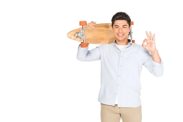 Alegre Ásia Homem Segurando Longboard Mostrando Sinal Isolado Branco — Fotografia de Stock