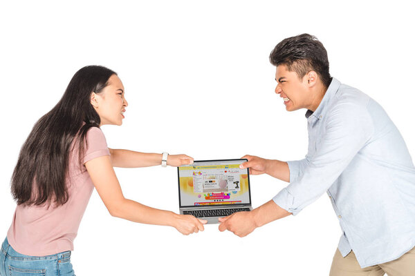 KYIV, UKRAINE - JUNE 18, 2019: angry asian man and woman holding laptop with Aliexpress website on screen isolated on white