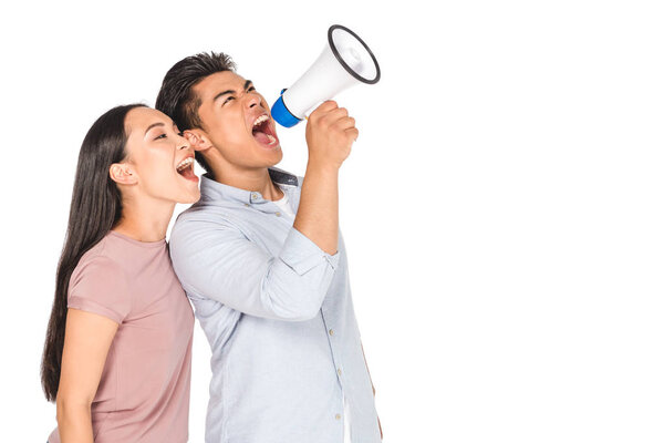 young asian couple screaming into megaphone together isolated on white