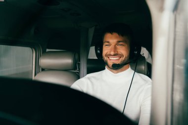 uçakta kulaklık gülümseyen yakışıklı sakallı pilot