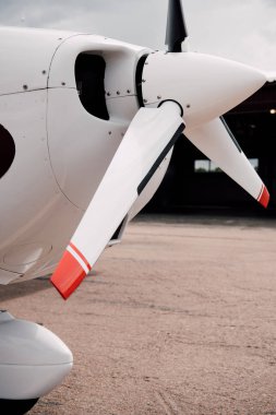 white plane with big propeller on ground under sky clipart