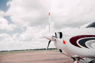 white plane at aerodrome under cloudy overcast sky clipart
