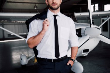 uçağın yanında cebinde el ile duran kendinden emin pilot kısmi görünümü