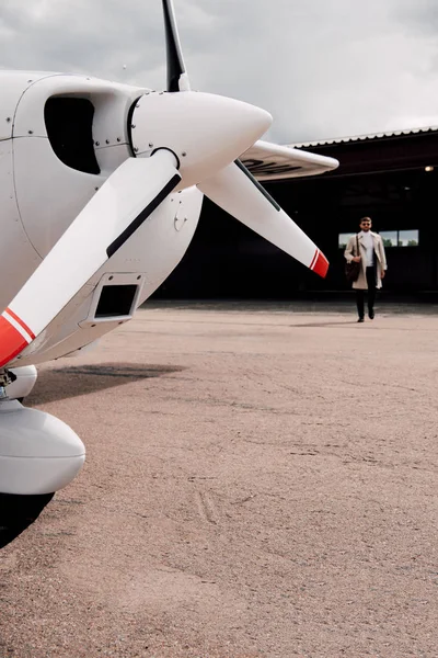 Ganzkörperansicht Des Mannes Mantel Mit Tasche Und Flugzeug Vordergrund — Stockfoto