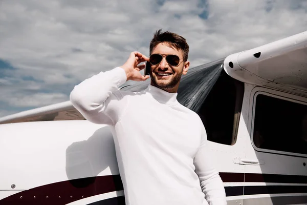 Smiling Bearded Man Sunglasses Talking Smartphone Plane — Stock Photo, Image