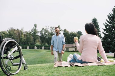 gülümseyen erkek arkadaşı yakın elma tutan engelli kadın geri görünümü 