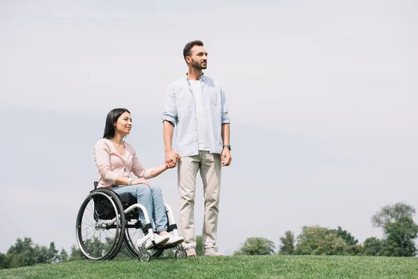 Knappe Jonge Man Holding Handen Met Gehandicapte Vriendin Zittend Rolstoel — Stockfoto