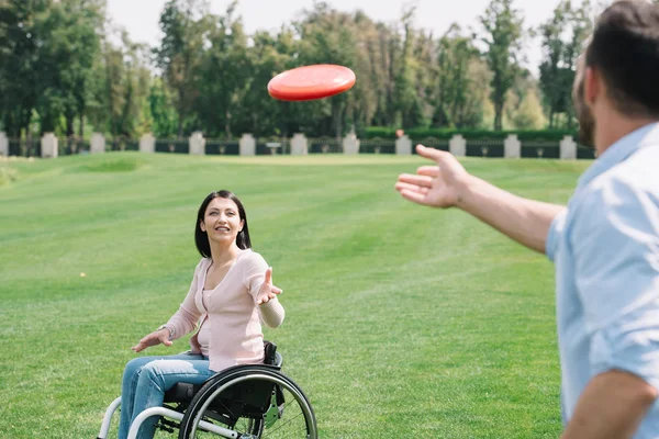 Młody Człowiek Rzucanie Flying Disc Niepełnosprawnych Dziewczyny Parku — Zdjęcie stockowe