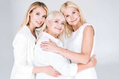 three generation blonde women embracing isolated on grey clipart