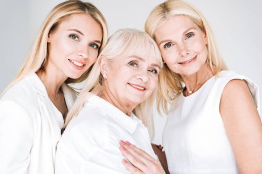 three generation blonde women hugging isolated on grey clipart