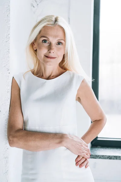 Sorridente Donna Matura Bionda Vicino Muro Bianco Alla Finestra — Foto Stock