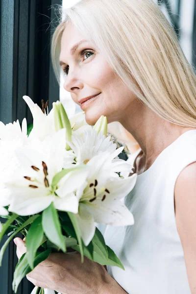 Porträtt Blond Mogen Kvinna Med Vita Blommor Tittar Genom Fönstret — Stockfoto