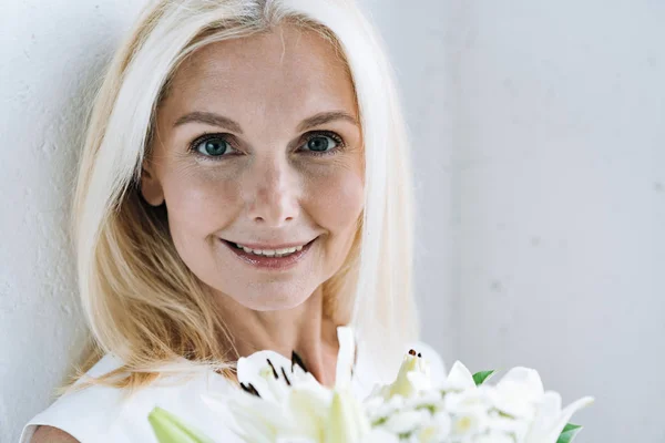 Mujer Madura Rubia Feliz Con Flores Blancas Cerca Pared Blanca —  Fotos de Stock