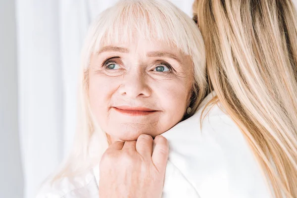 Блондинка Усміхнена Бабуся Ніжно Обіймає Онуку — стокове фото