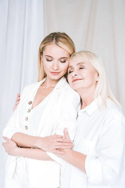 Pleased Blonde Grandmother Granddaughter Hugging Total White Outfits Closed Eyes — Stock Photo, Image