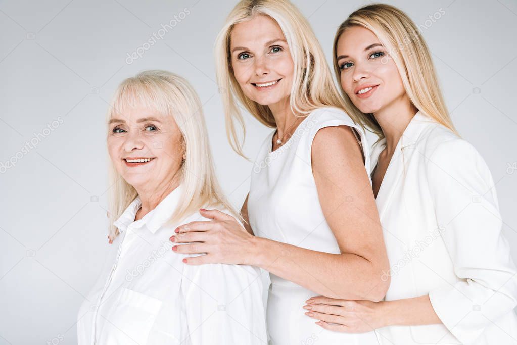 side view of three generation blonde women isolated on grey