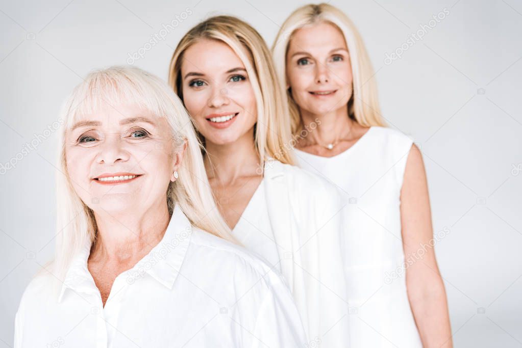selective focus of attractive three generation blonde women isolated on grey