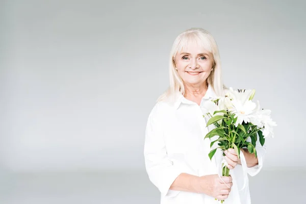 Glücklich Blonde Seniorin Weißen Kleidern Mit Blumen Isoliert Auf Grau — Stockfoto