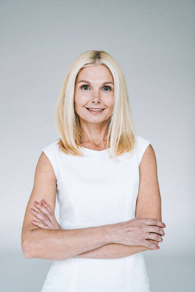 Улыбающаяся блондинка, зрелая женщина со скрещенными руками
