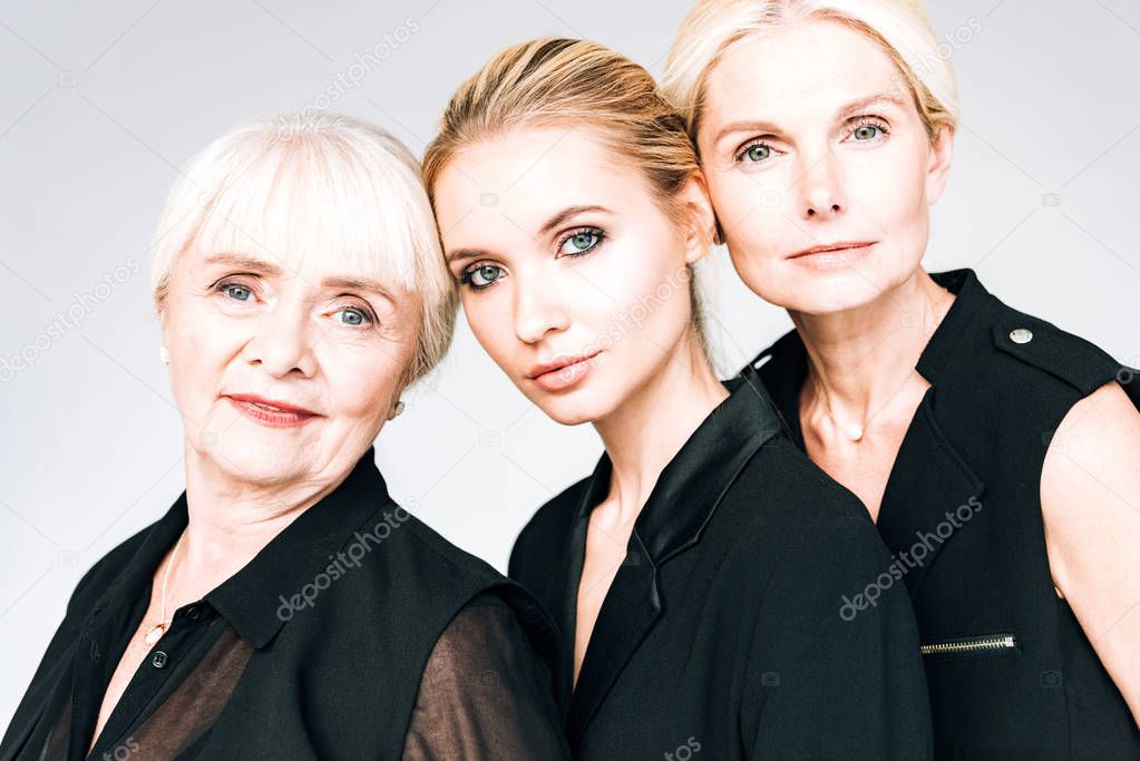 three-generation blonde women in total black outfits isolated on grey