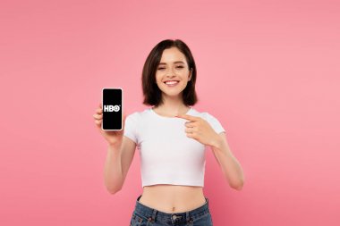 Kiev, Ukrayna - 3 Temmuz 2019: Hbo logolu akıllı telefona parmakla işaret eden gülümseyen kız.