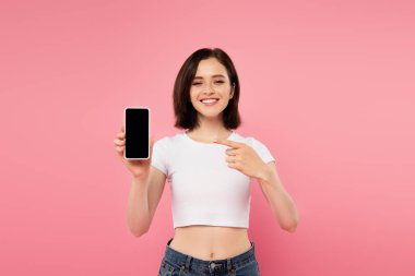 pembe izole boş ekran ile akıllı telefon parmak ile işaret gülümseyen kız