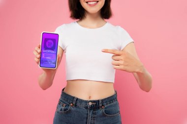 pembe izole alışveriş uygulaması ile akıllı telefonda parmak ile işaret kız kırpılmış görünümü