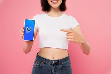 Kiev, Ukrayna - 3 Temmuz 2019: pembe izole shazam logosu ile akıllı telefon parmak ile işaret kız kırpılmış görünümü