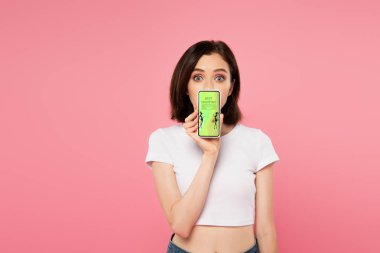 pembe izole alışveriş ile akıllı telefon tutan sürpriz kız