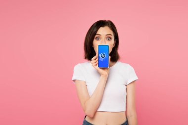 Kiev, Ukrayna - 3 Temmuz 2019: pembe izole shazam logolu akıllı telefon tutan şok kız